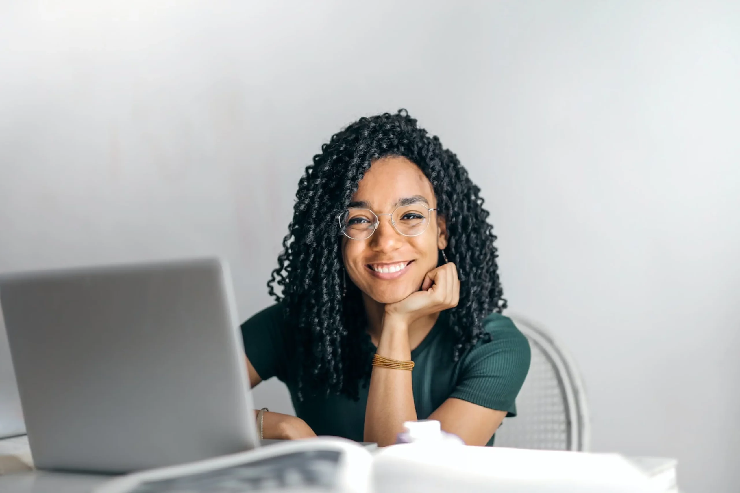 woman smiling at camera while on her laptop