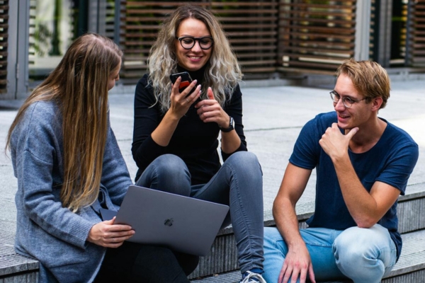 three students sat on steps
